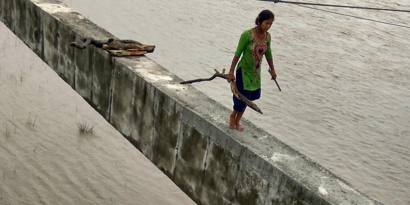 A woman walks with firewood collected from Mahakali River A woman walks with firewood collected from Mahakali River